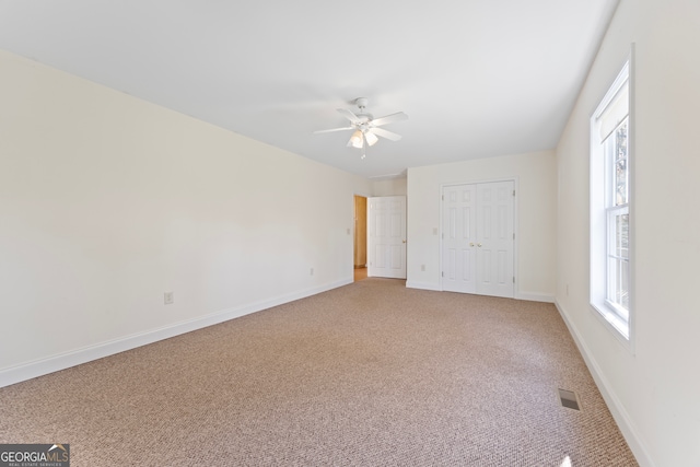 unfurnished bedroom with carpet flooring, ceiling fan, and a closet