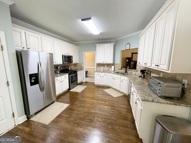 kitchen featuring sink, decorative backsplash, appliances with stainless steel finishes, dark hardwood / wood-style flooring, and white cabinetry