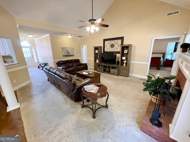 carpeted living room with ceiling fan and high vaulted ceiling