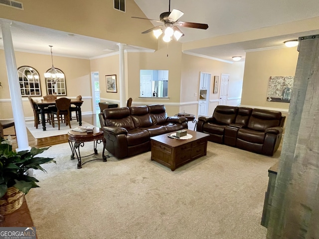 living room with ceiling fan with notable chandelier, decorative columns, crown molding, and light colored carpet