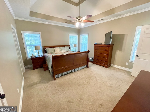 carpeted bedroom with ceiling fan, a raised ceiling, ornamental molding, and multiple windows