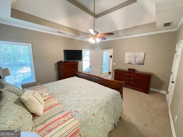 bedroom featuring light carpet, a raised ceiling, ceiling fan, and crown molding