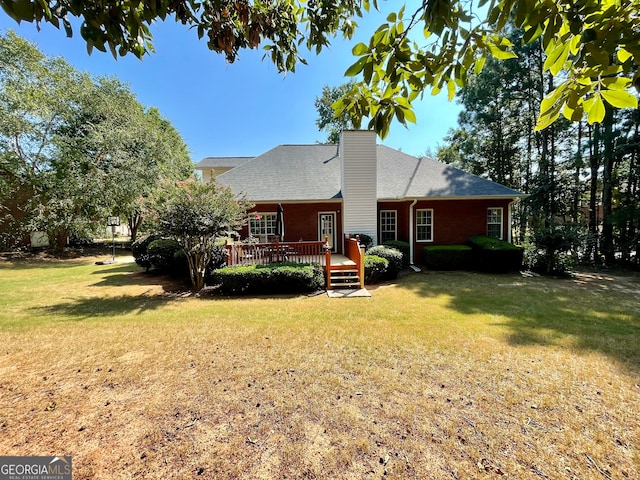 back of property with a lawn and a wooden deck