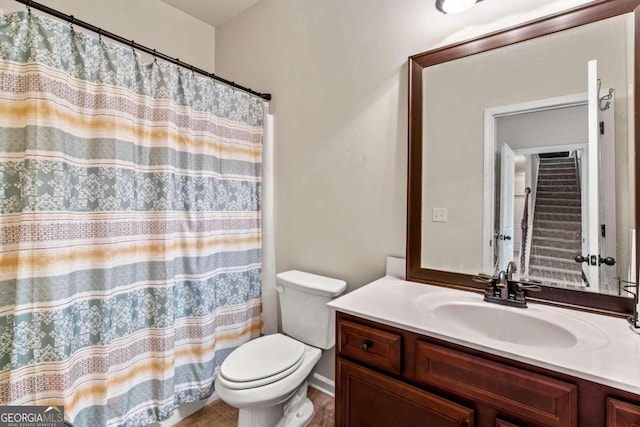 bathroom with tile patterned flooring, vanity, and toilet