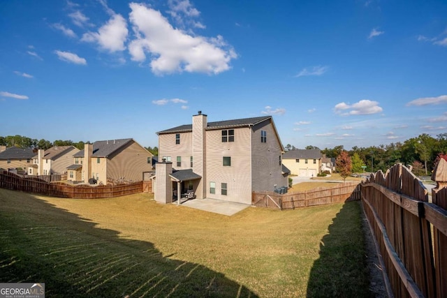 back of house featuring a patio area and a lawn