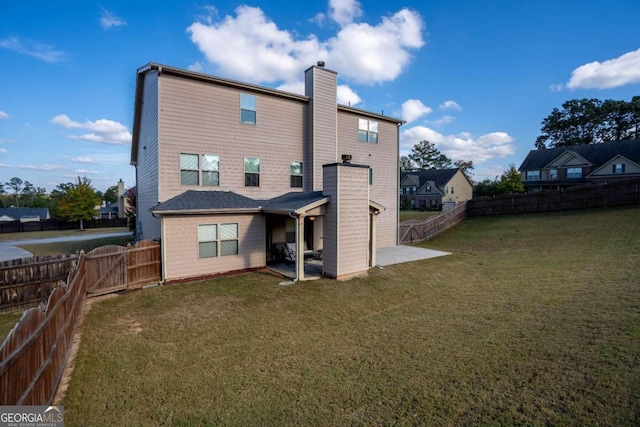 rear view of property featuring a yard and a patio