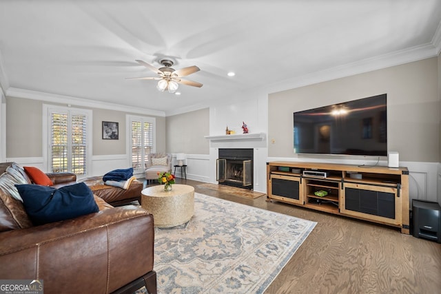 living room featuring ceiling fan, ornamental molding, and hardwood / wood-style flooring