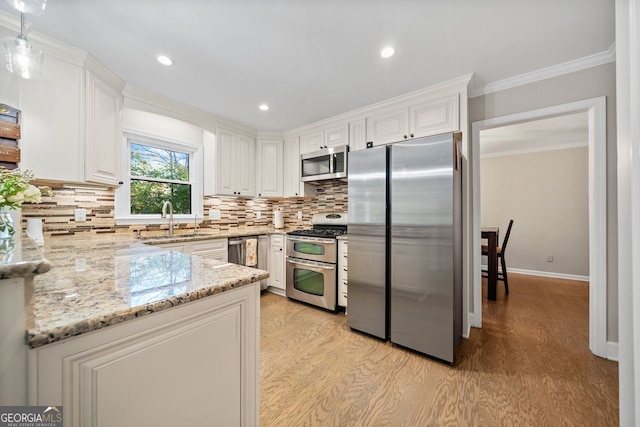 kitchen featuring light stone countertops, white cabinetry, appliances with stainless steel finishes, and light hardwood / wood-style flooring