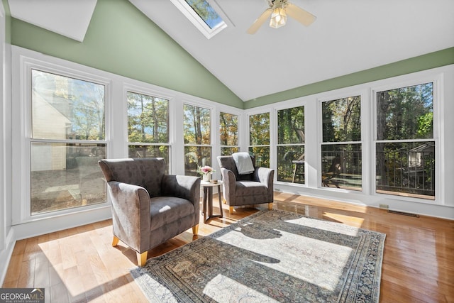 sunroom / solarium with ceiling fan and vaulted ceiling with skylight