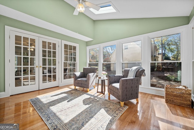 sunroom with vaulted ceiling with skylight, ceiling fan, a wealth of natural light, and french doors