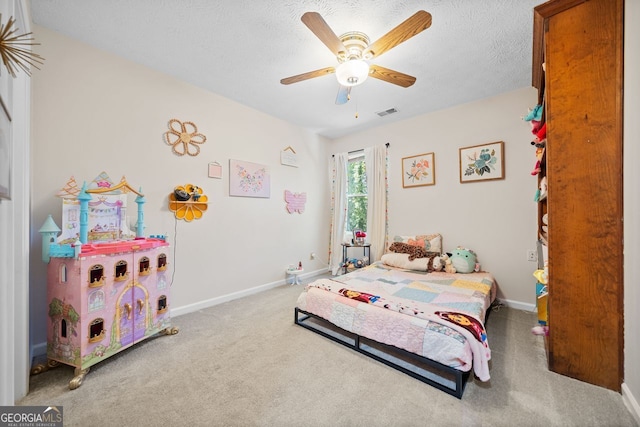 carpeted bedroom featuring ceiling fan and a textured ceiling