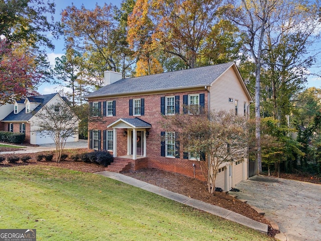 colonial-style house featuring a front yard and a garage