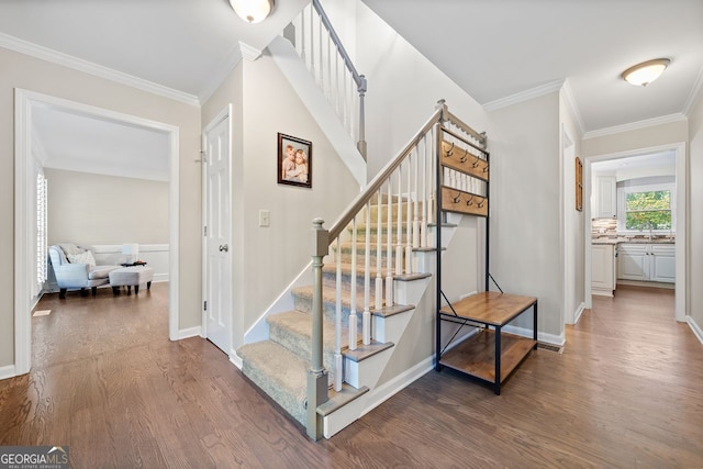 stairway with hardwood / wood-style floors and ornamental molding