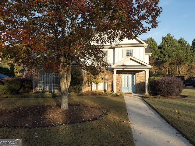 view of front of home featuring a front yard and french doors