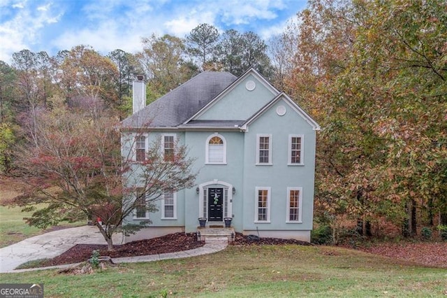 colonial home featuring a front yard