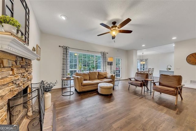 living room with ceiling fan, a fireplace, and wood-type flooring