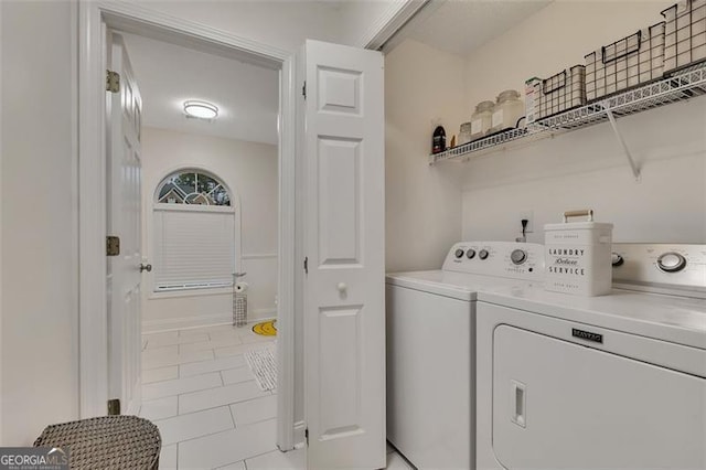 laundry area featuring washing machine and dryer and light tile patterned floors