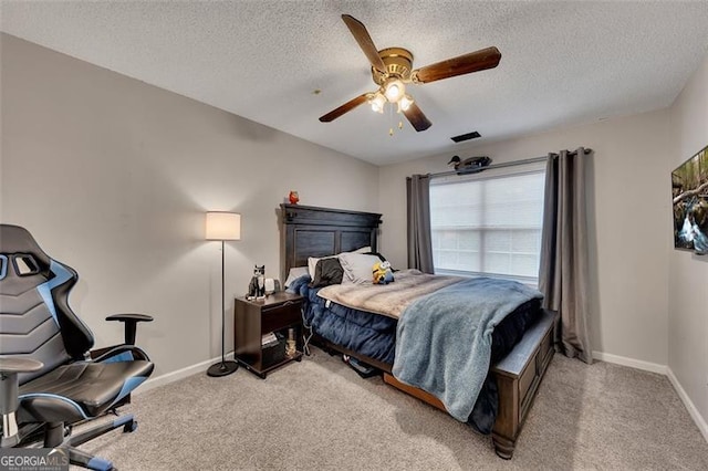 bedroom with a textured ceiling, light colored carpet, and ceiling fan