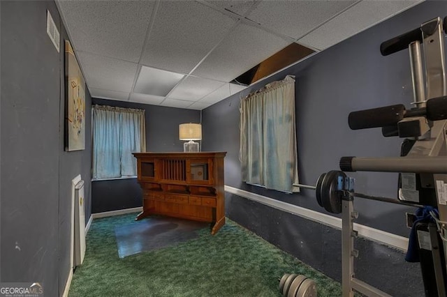 interior space with a paneled ceiling and carpet