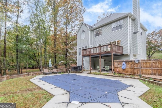 back of property featuring a patio and a covered pool