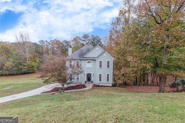 colonial inspired home with a front lawn