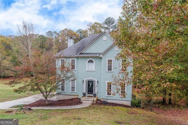 colonial-style house with a front lawn