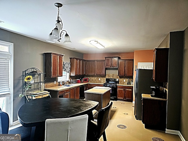 kitchen featuring sink, dark brown cabinets, a kitchen island, decorative backsplash, and black appliances