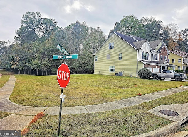 view of home's exterior featuring central AC, a garage, and a lawn