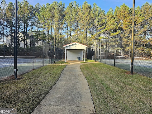 view of tennis court with a yard