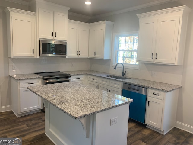 kitchen with white cabinetry, sink, a center island, dark wood-type flooring, and appliances with stainless steel finishes