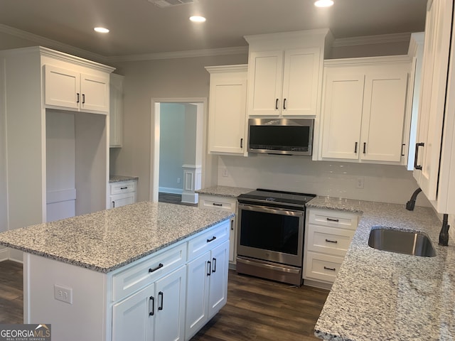 kitchen with light stone countertops, white cabinetry, dark wood-type flooring, and appliances with stainless steel finishes