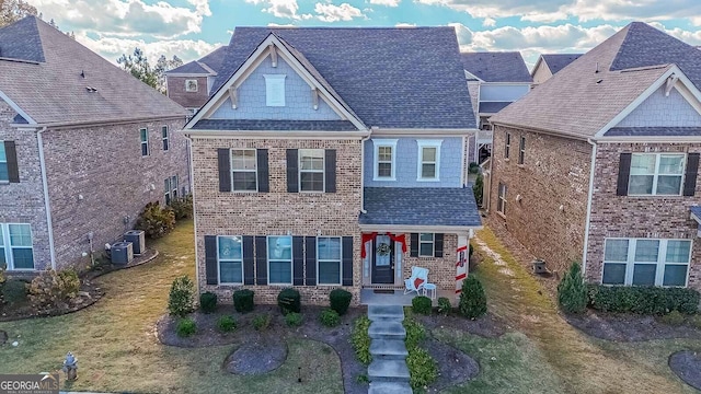 view of front of home with central AC unit and a front yard