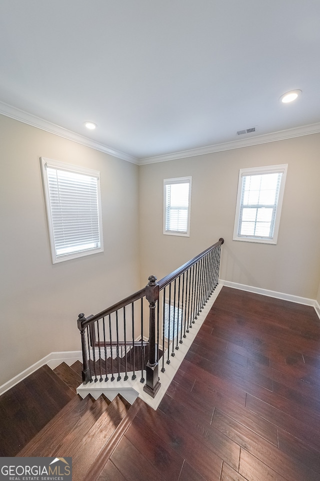 staircase with hardwood / wood-style floors, a wealth of natural light, and crown molding