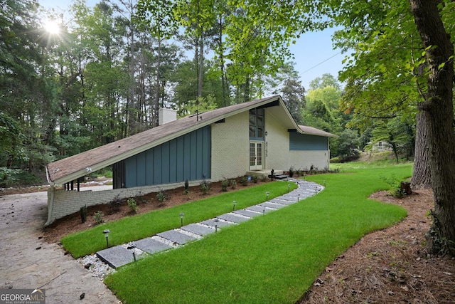 view of side of home with a lawn