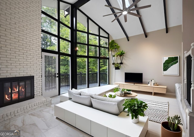 living room with ceiling fan, a fireplace, high vaulted ceiling, and a healthy amount of sunlight