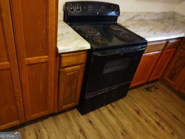 kitchen featuring light hardwood / wood-style floors and black range with electric stovetop