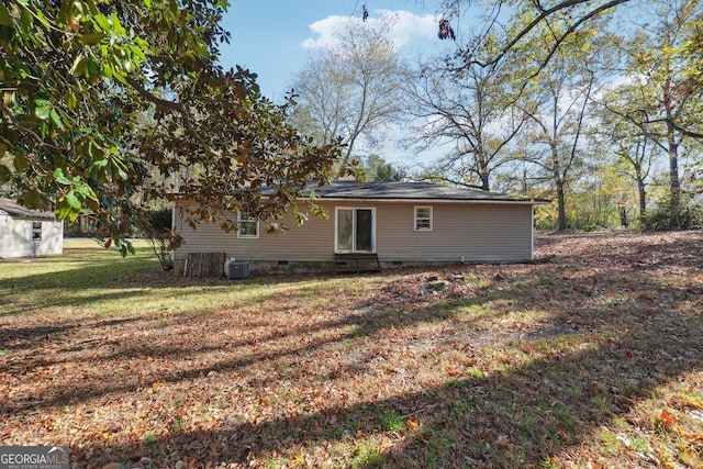 rear view of house with a lawn and central AC