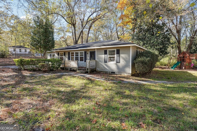 single story home with a playground and a front lawn