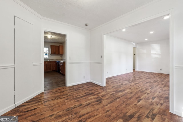 unfurnished room with ornamental molding, a textured ceiling, and dark wood-type flooring