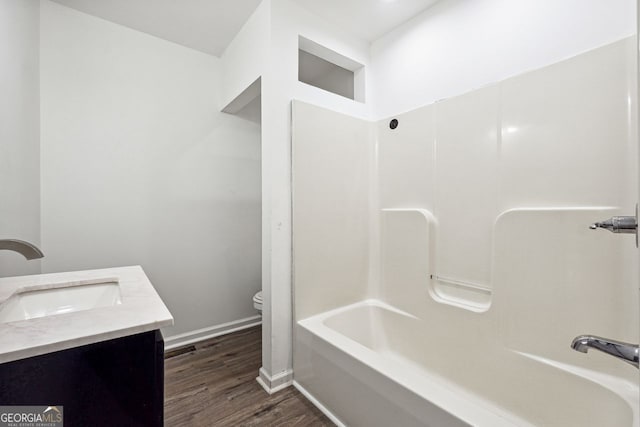 full bathroom featuring vanity, wood-type flooring,  shower combination, and toilet