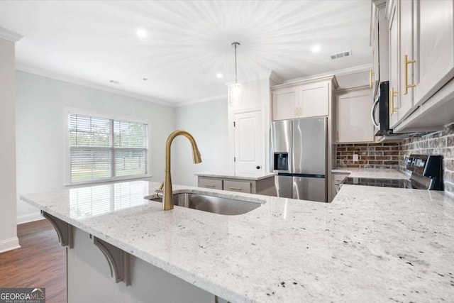 kitchen featuring light stone countertops, dark hardwood / wood-style flooring, stainless steel appliances, sink, and hanging light fixtures