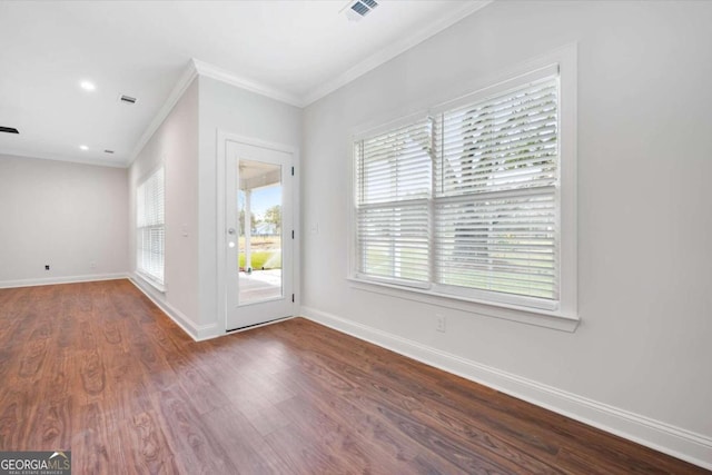 spare room with crown molding and dark wood-type flooring