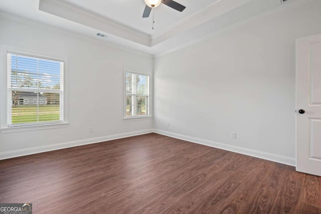 spare room with dark hardwood / wood-style flooring, a raised ceiling, ceiling fan, and ornamental molding