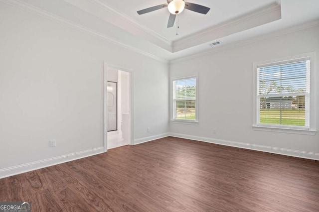 spare room with dark hardwood / wood-style floors, a tray ceiling, crown molding, and ceiling fan