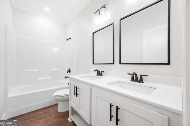 full bathroom featuring bathing tub / shower combination, wood-type flooring, toilet, vanity, and ornamental molding