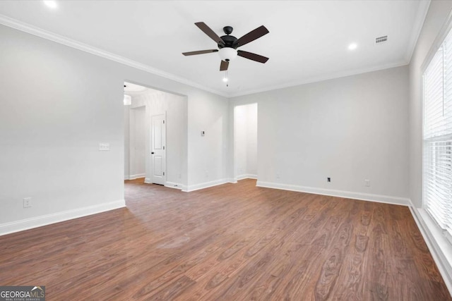 empty room with ornamental molding, ceiling fan, and dark wood-type flooring