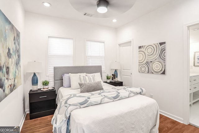 bedroom featuring connected bathroom, ceiling fan, and dark wood-type flooring