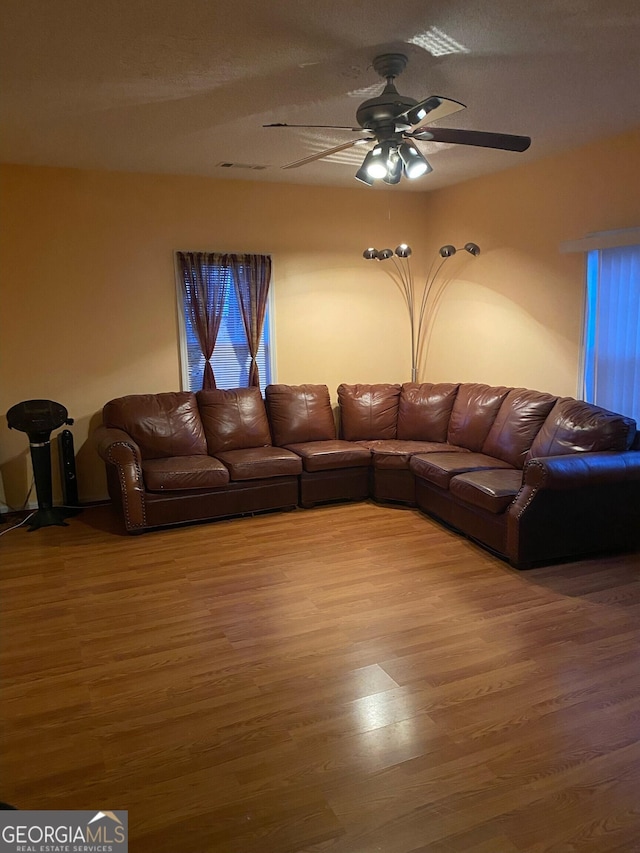 unfurnished living room featuring hardwood / wood-style flooring, a textured ceiling, and ceiling fan