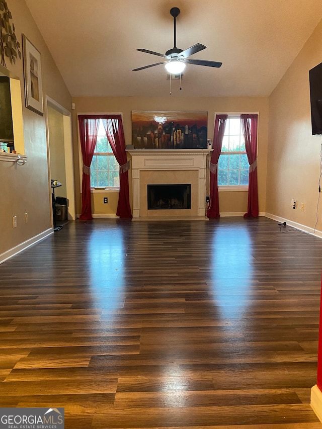 unfurnished living room featuring ceiling fan, a healthy amount of sunlight, lofted ceiling, and dark hardwood / wood-style flooring