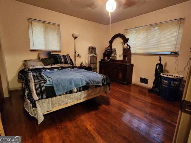 bedroom with dark hardwood / wood-style floors and ceiling fan